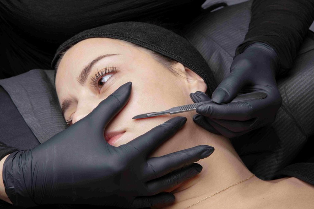 Cosmetologist in a beauty center performing a beauty treatment for the skin of the face with the dermaplaning technique | Mandalyn Academy in American Fork, UT