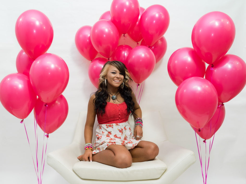 A Young lady sitting on a chair and around her pink ballons flying | Mandalyn Academy in American Fork UT