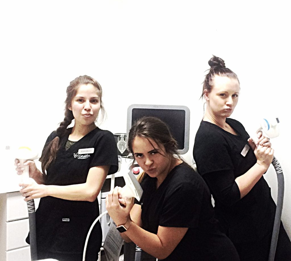 Group of ladies holding treatment devices in action of gun | Mandalyn Academy in American Fork UT