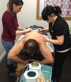 A Man getting treatment by two nurse on back | Mandalyn Academy in American Fork UT